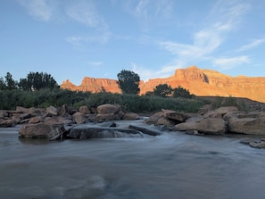 A river flowing through a rocky landscape with a mountain in the background. - Palisade Tent at Gateway Glamping (Gateway)
