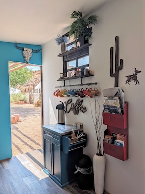 A room with a coffee station, a cactus decoration, and a window with a view of an outdoor area.