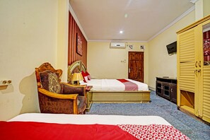 Une chambre d’hôtel avec un lit, une chaise, une télévision et une armoire.