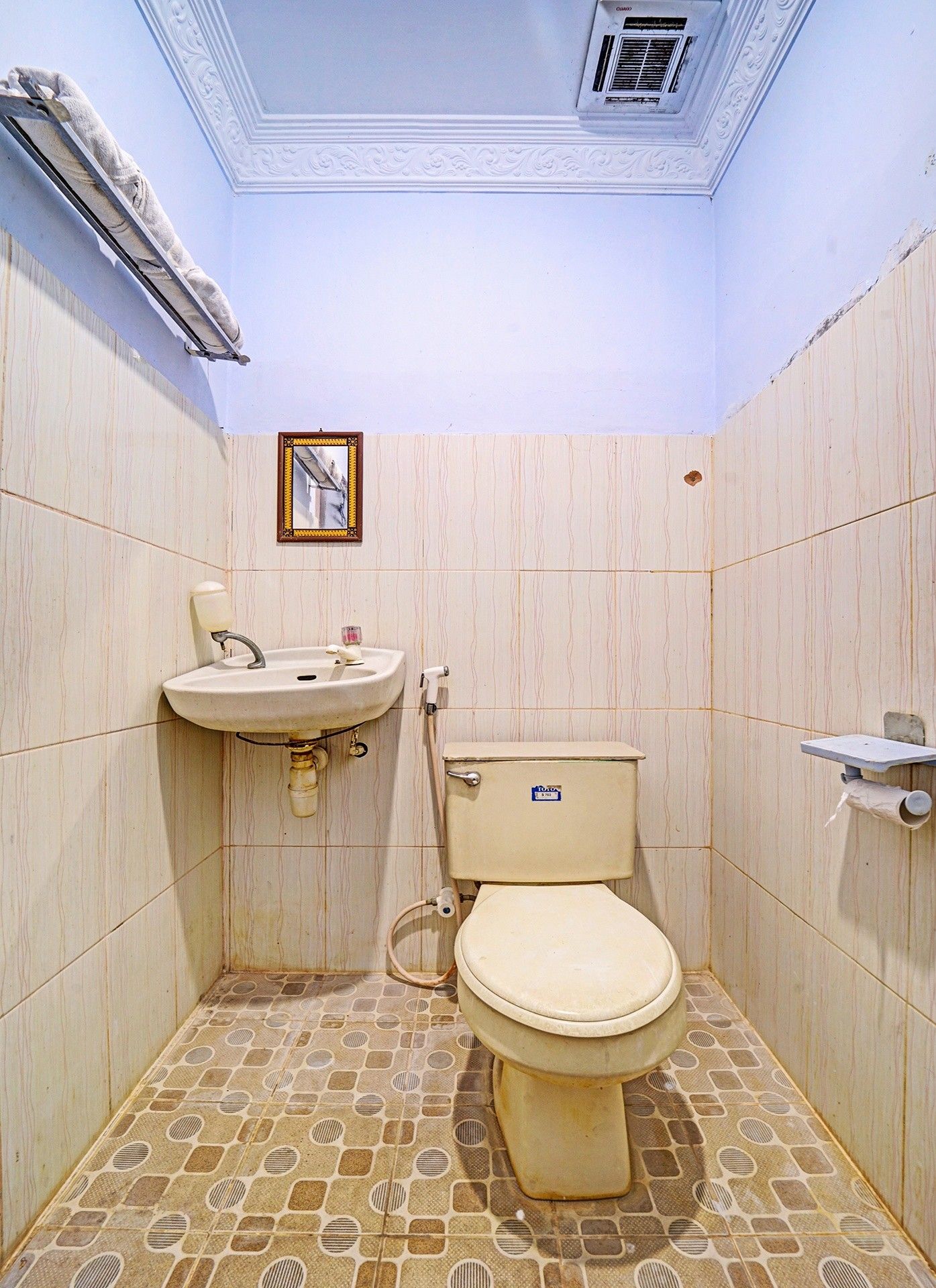A small bathroom with a toilet, sink, and mirror.