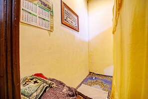 Una habitación con una cama, un calendario y un cuadro en la pared.