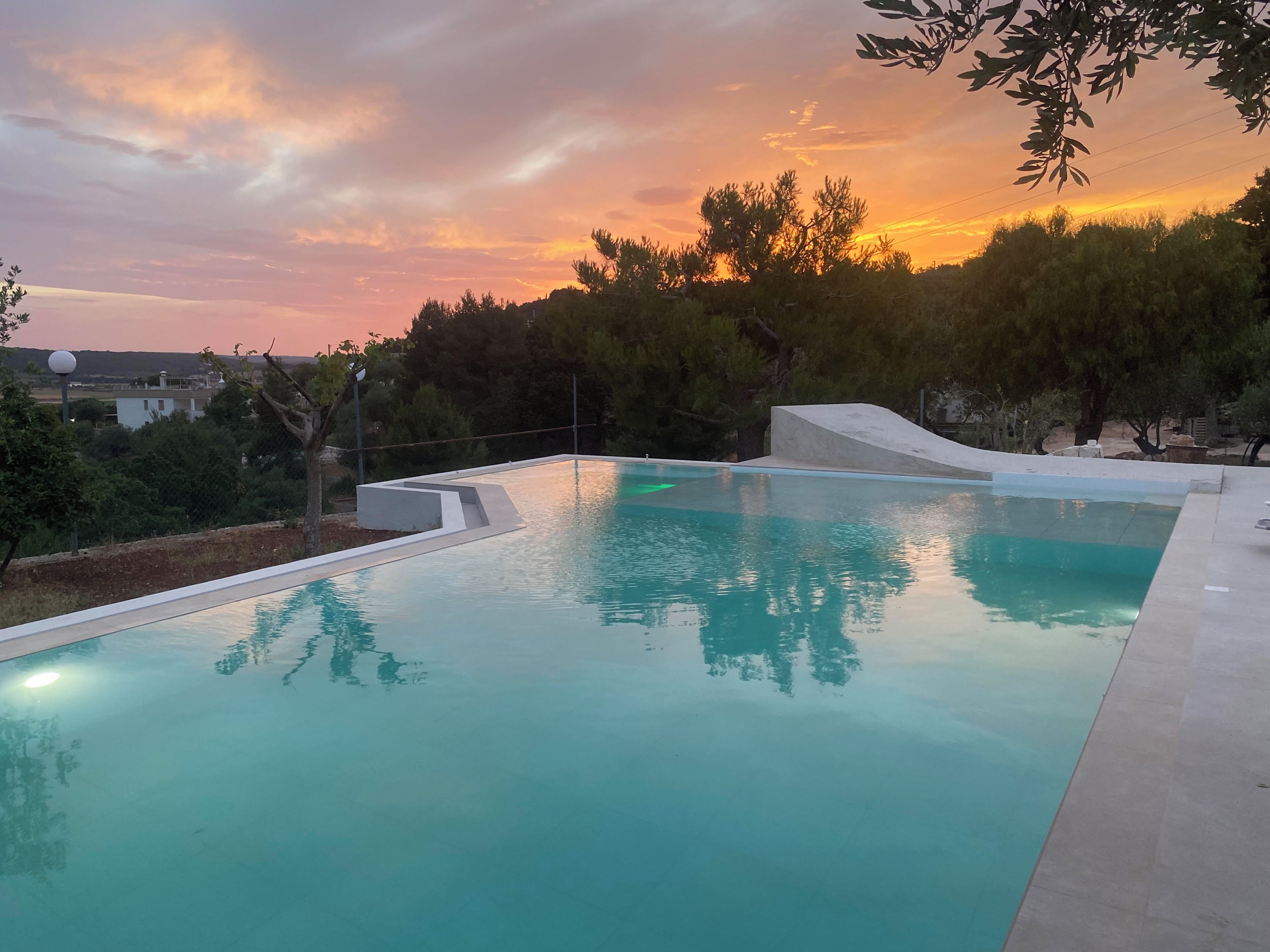 Una piscina con una vista despejada del atardecer al fondo.