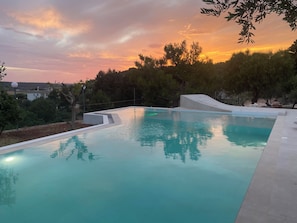 Una piscina con una vista despejada del atardecer al fondo.