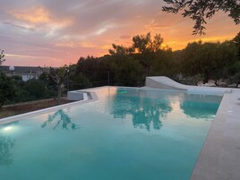Una piscina con vista libera sul tramonto.