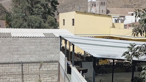 A rooftop pool area with a view of a hill and a church.