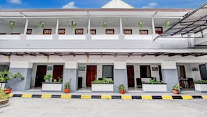 A two-story building with a flat roof, multiple balconies, and potted plants. - Hotel O Mamagayo Inn (Yogyakarta)