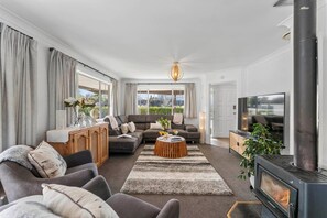 Un salon moderne comprenant un canapé, une table basse, une cheminée et un téléviseur.