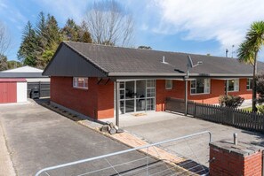 Un bâtiment d’un seul étage, doté d’un toit en pente, d’une antenne parabolique et d’une allée bordée d’une clôture.