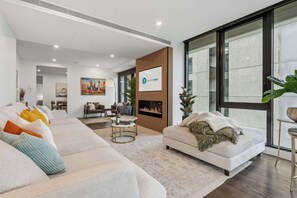 Un salon moderne avec une cheminée, un ensemble de canapés et un coin repas.