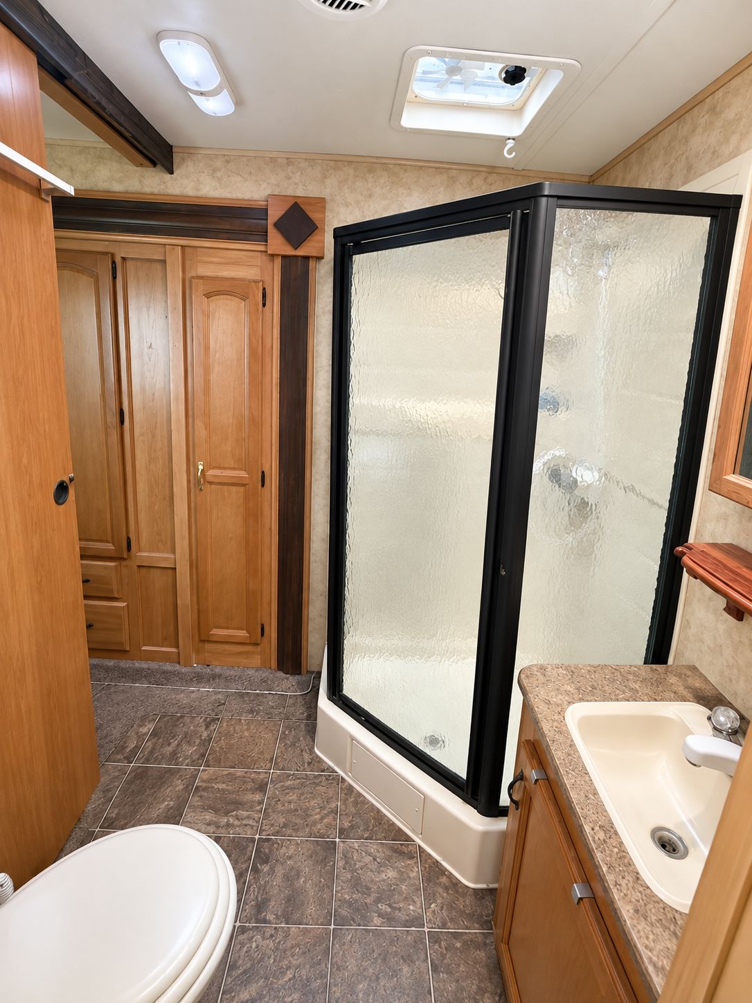 A compact bathroom with a shower enclosure, a toilet, and a sink.