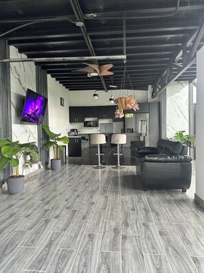 Un interior moderno con cocina, zona de bar y asientos.