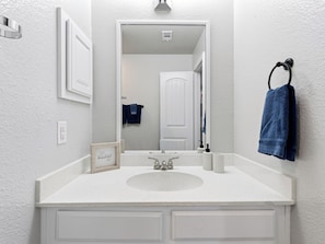 Ein Badezimmer mit Waschbecken, Spiegel und Handtuchhalter.