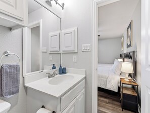 Une salle de bain avec un lavabo blanc, un miroir et un porte-serviettes.