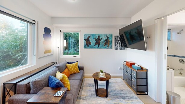 A modern living room with a sofa, coffee table, and artwork on the walls. - A little retreat in Seattle perfect for your next getaway (Seattle)
