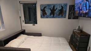 A bedroom with a bed, a TV, a window, and artwork on the wall. - A little retreat in Seattle perfect for your next getaway (Seattle)