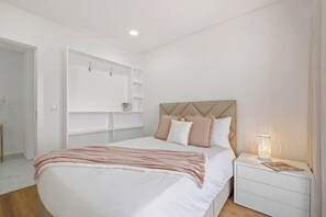 A bedroom with a bed, bedside tables, a wall-mounted shelf unit, and a bedside lamp. - CableCar House I, by Pausa Vacation Rentals (Câmara de Lobos)