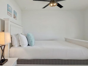 A bedroom with a bed, a ceiling fan, a nightstand with a lamp, and a tiled floor. - Lakeside 4BR w Pool, Hot Tub, Dock, B-Ball Court (Leander)