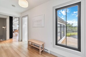 Ein modernes Interieur mit einem großen Fenster, einer Sitzbank und einem gerahmten Zitat an der Wand.