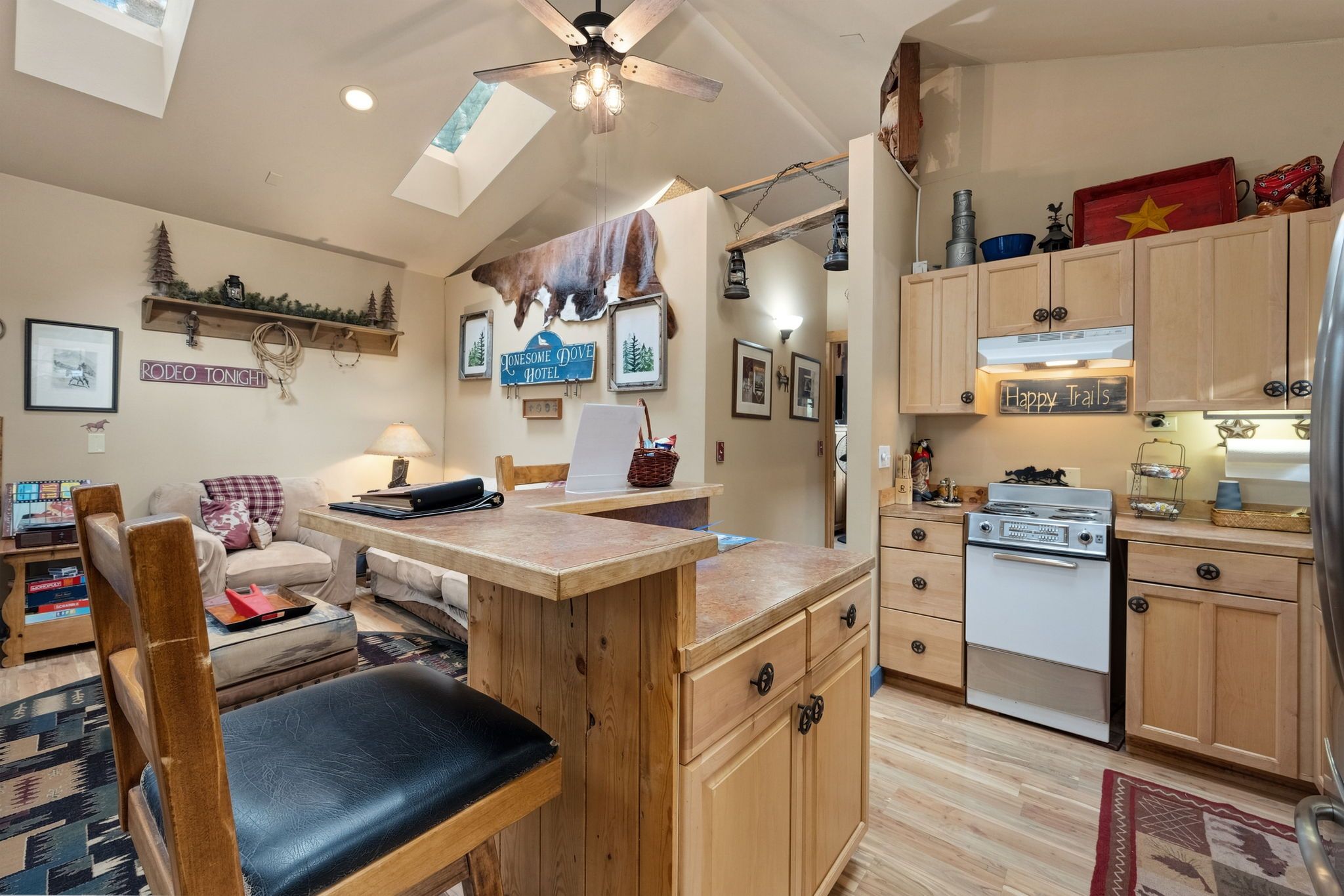 A cozy kitchen with wooden cabinets, a built-in stove, and a dining area with a table and chairs.