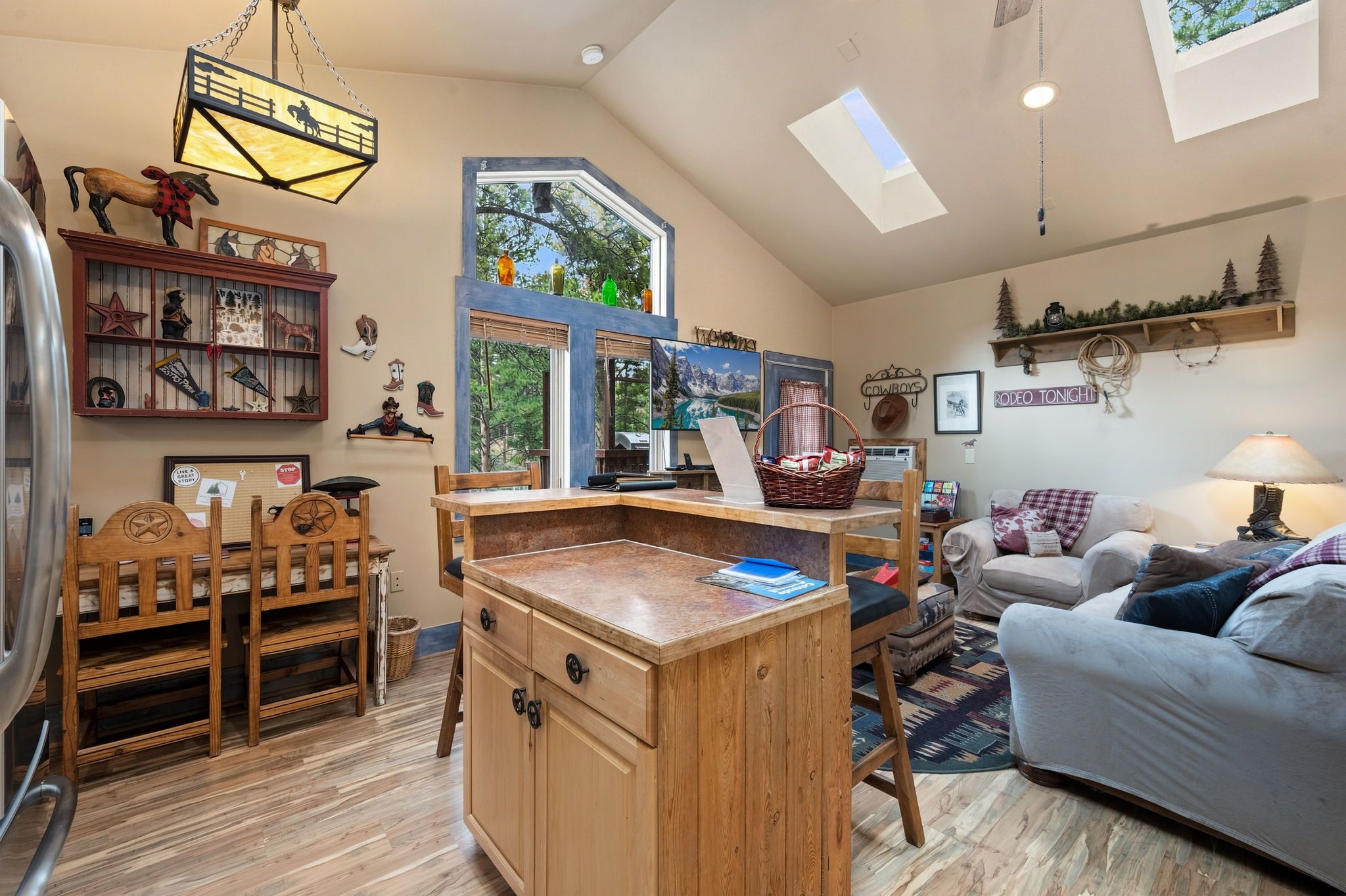 Un salon chaleureux avec un bureau en bois, un canapé et un coin repas avec des chaises.
