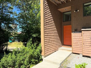 Un bâtiment à l’extérieur en briques, avec une porte en bois et une petite fenêtre.