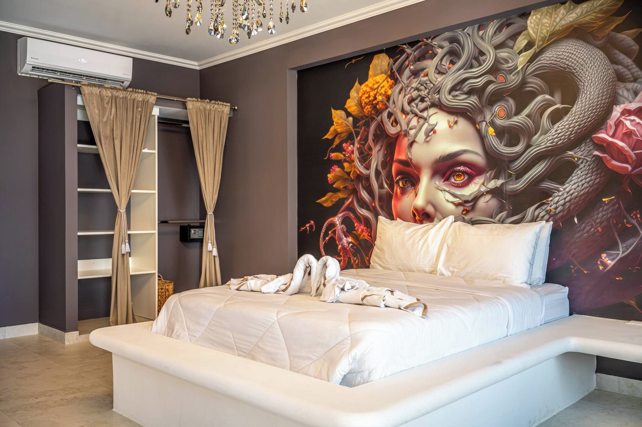 Ein modernes Schlafzimmer mit einem großen Bett, einer Wand-Klimaanlage und einem dekorativen Wandgemälde.