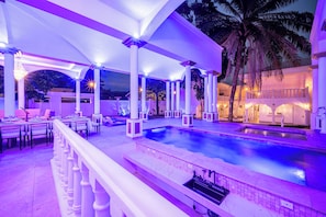 A poolside area with a covered seating area and a swimming pool. - The Palace 10br Villa Luxury Pool, Jacuzzi, Resort Style Bar (Jacó)