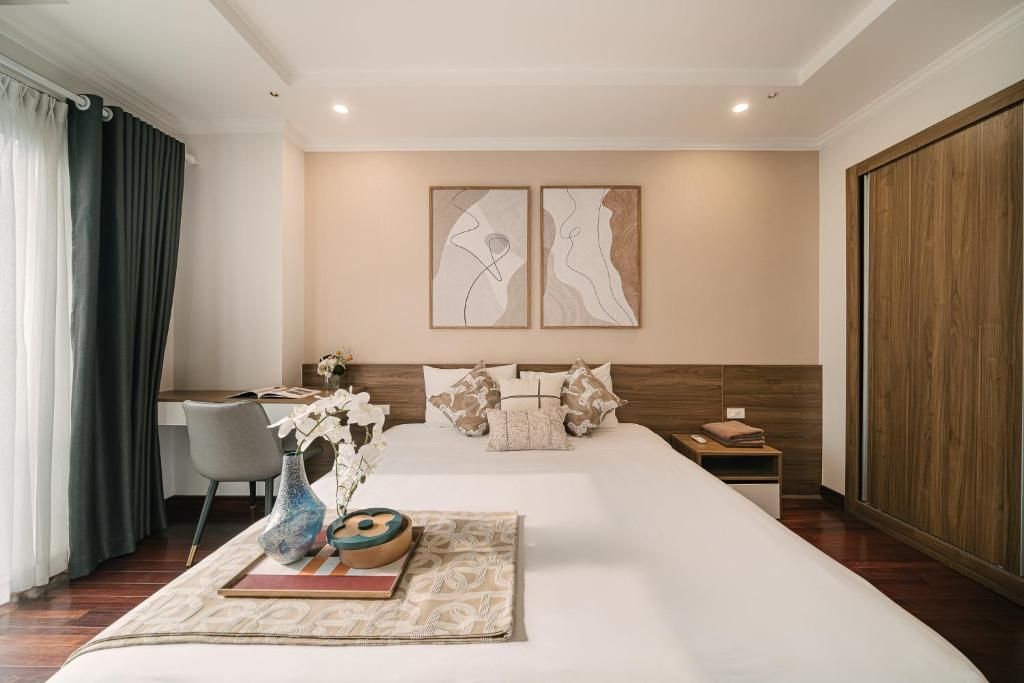 Una habitación de hotel con una cama grande, un escritorio y dos obras de arte colgadas en la pared.