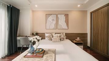 Una habitación de hotel con una cama grande, un escritorio y dos obras de arte colgadas en la pared.