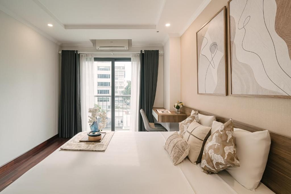 A hotel room with a bed, a desk, a chair, and a view of the outside.