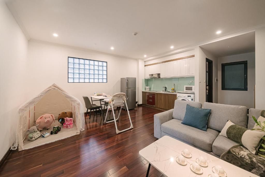 Un espace de vie compact comprenant un coin repas, une kitchenette et un espace de jeux confortable pour les enfants.