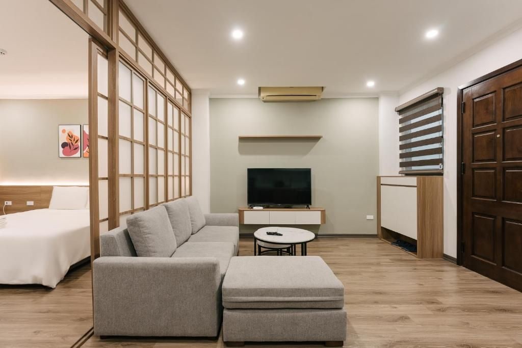 A modern living room with a sectional sofa, a small round table, and a television.