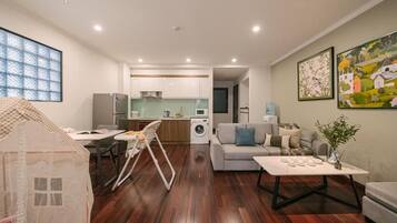 A modern apartment with a dining area, kitchen, living room, and a playhouse.