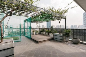 A rooftop terrace with a pergola, potted plants, and a view of the city skyline. - Hanoi Lux Lakeside Hotel and Apartment (Giang Vo)