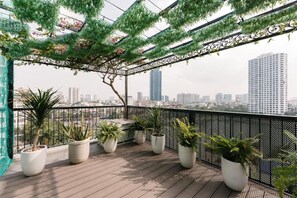 Varanda com vasos de plantas e vista para a cidade.