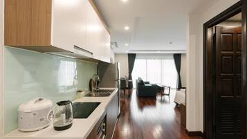 A modern kitchen with a built-in stove and a dining area with a sofa and table.