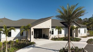 A modern two-story house with a covered patio, palm trees, and a paved driveway. - 4BR Storey Lake Private Pool & BBQ Near Disney (Kissimmee)
