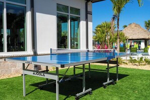 An outdoor ping pong table in front of a building with a sign that reads 'ESTROOM'. - 4BR Storey Lake Private Pool & BBQ Near Disney (Kissimmee)