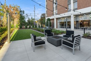 An outdoor seating area with modern furniture, a fire pit, and a well-maintained lawn. - Cozy Chic Downtown Birmingham Studio  Free Parking Near Dining & Entertainment (Birmingham)