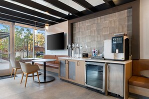A modern bar area with a flat-screen TV, a coffee machine, and a refrigerator. - Cozy Chic Downtown Birmingham Studio  Free Parking Near Dining & Entertainment (Birmingham)