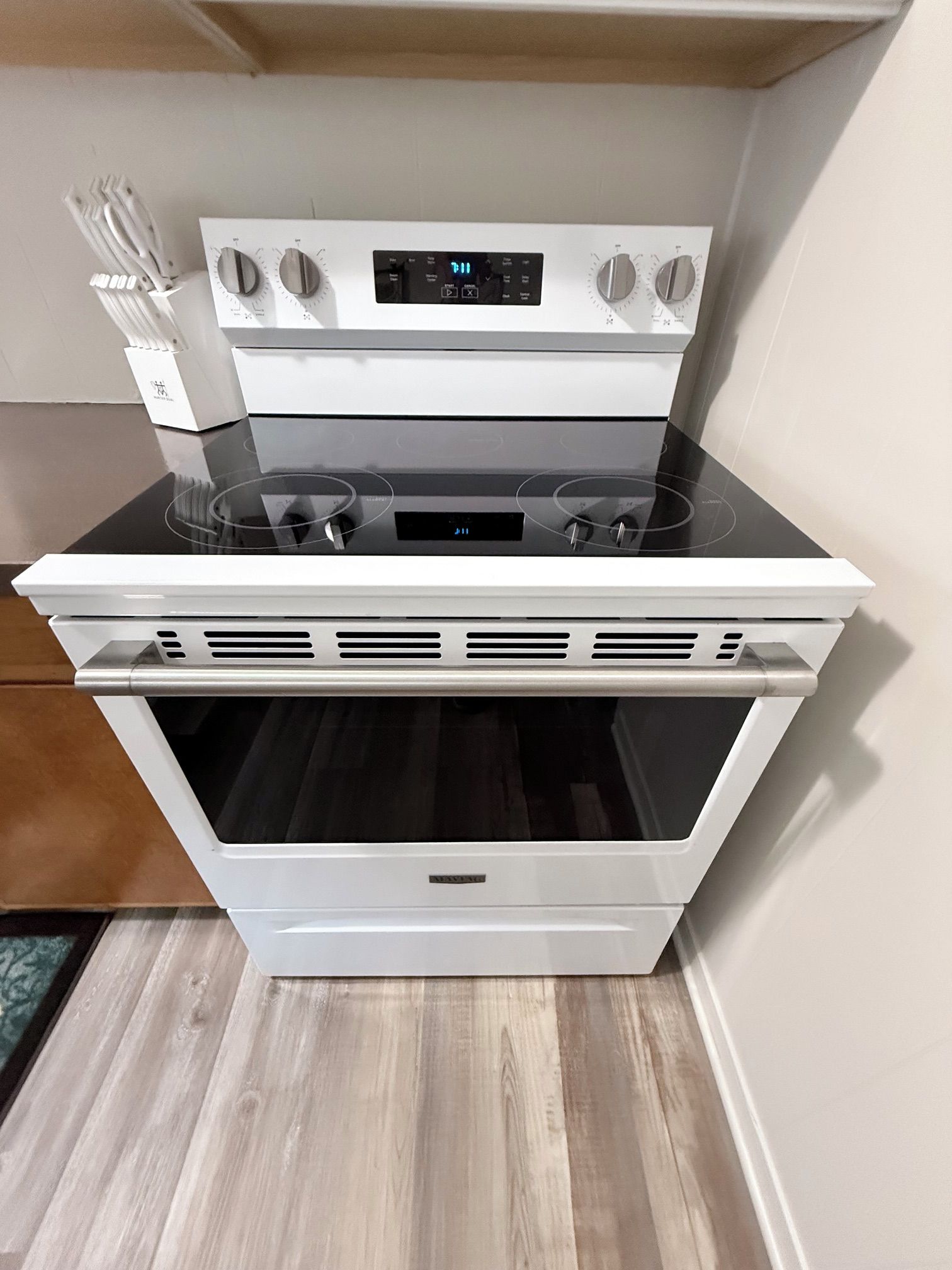 Un four blanc doté d’un écran numérique, d’une plaque de cuisson et d’une porte de four intégrée.