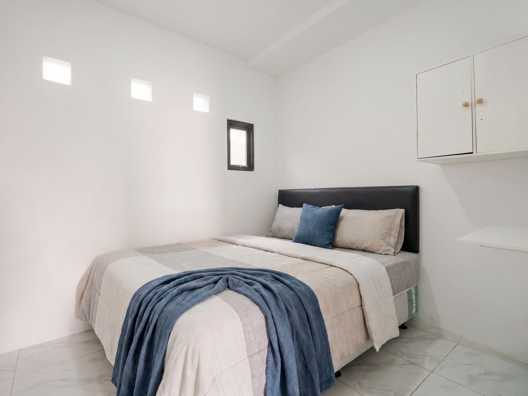 Une chambre à coucher avec un lit, une armoire et une fenêtre.