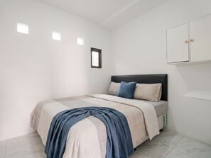Un dormitorio con cama, armario y ventana.