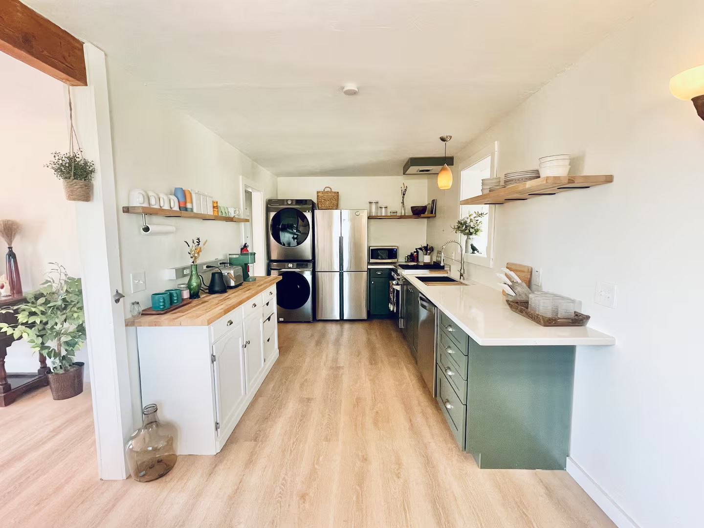 Uma cozinha moderna com uma ilha central, eletrodomésticos embutidos e piso de madeira.