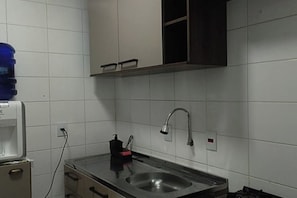 Een keuken met een roestvrijstalen spoelbak, een kraan en een waterdispenser.