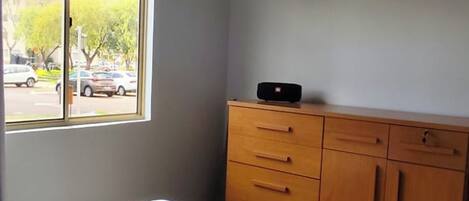 Habitació amb un llit, una finestra i un taulell de fusta.