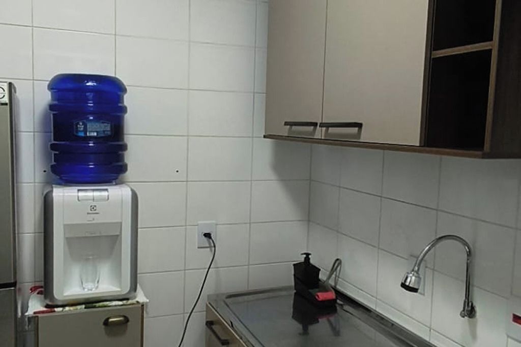 Una cocina con dispensador de agua, grifo y un mueble.