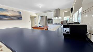 A modern kitchen with a dark countertop, white cabinets, and a built-in oven.