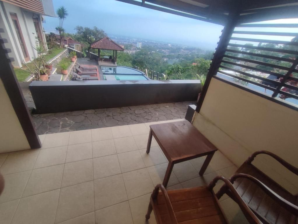 A balcony with a view of a swimming pool and surrounding greenery.