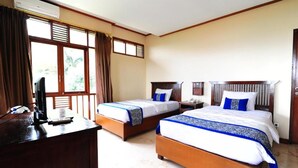 A hotel room with two beds, a desk with a computer, and a window with curtains. - Dago Highland Resort (Bandung)